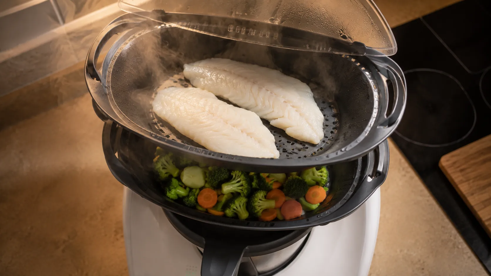 Recipiente Varoma de un robot de cocina con pescado y verduras cocinándose al vapor en dos niveles distintos